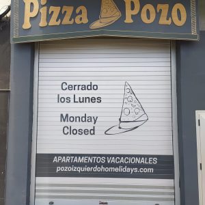 Fachada en chapa marina CNC y pintada y vinilo de larga duración de corte sobre la puerta automática enrollable. Diseño de Mochita. Fachada Pizza Pozo